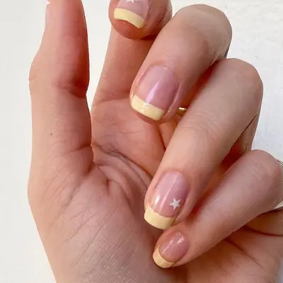 Cream French manicure with star accent nails