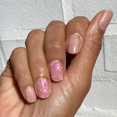 Sheer pink manicure with dotted floral accent nails