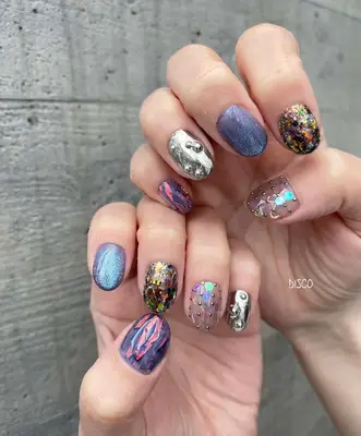 A multicolored chrome manicure with studs and other embellishments