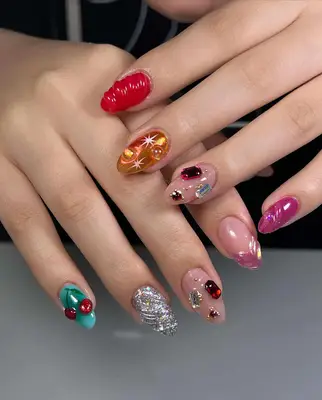A mismatched manicure with lots of embellishments including cherries, gems and glitter