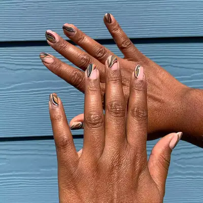 a negative space manicure with squiggles, grids, and other colorful designs