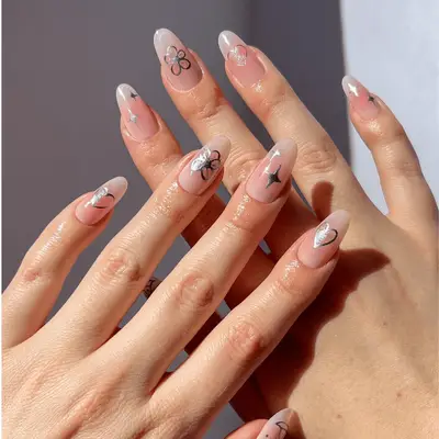 Close up of blush aura nails with silver icon decals,