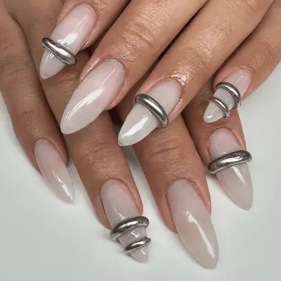 Milky nude nails with 3D rings wrapped around accent nails.