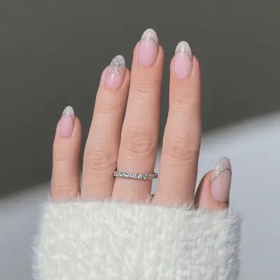 Nude nails with glittery silver lines and bows.