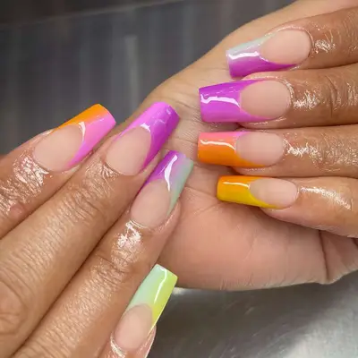 close up of nails in square shape with ombre french tips in colors of orange, pink, purple, yellow, green, orange