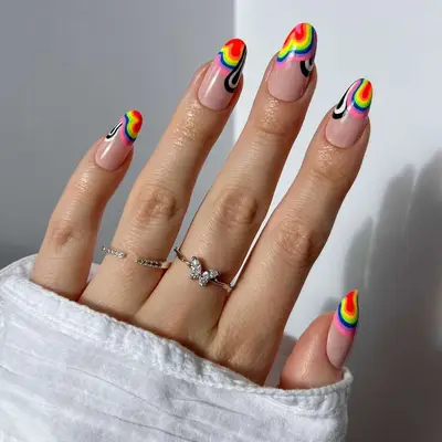 close up of nails with swirly tips in rainbow colors including red, pink, orange, yellow, green, blue, purple, black, white