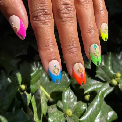 close up of nails with different colored french tips including pink, blue, orange, green, yellow, with gold sticker embellishments