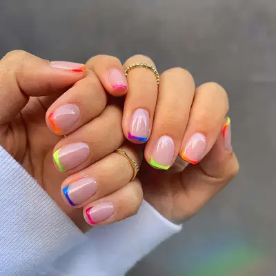 A short French manicure with rainbow ombrÃ© tips