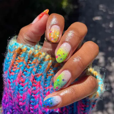 A rainbow French manicure with chunky glitter on top