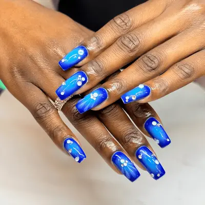 mid-length square blue aura nails with gem and water drop accents