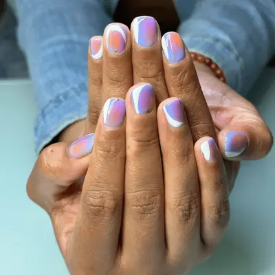 short natural aura nails with orange and pink center and purple base with white crescent design