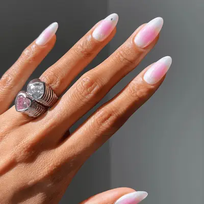 neutral white and pink aura nails with gem accent