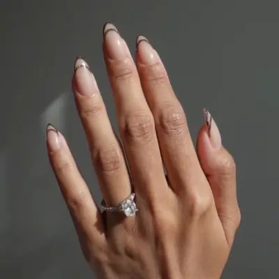 Nude French manicure with sparkly brown outlined tips