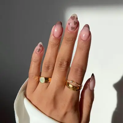 Manicure with brown French tips and brown heart accent nails