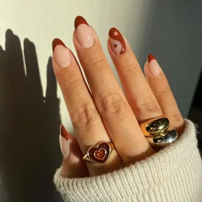 Manicure with brown French tips and yin/yang accent nail