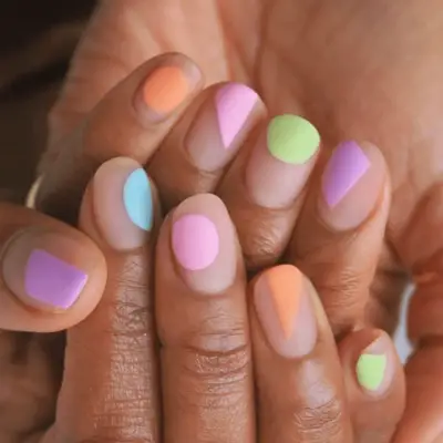 Pastel geometric manicure on short rounded nails and medium skin tone