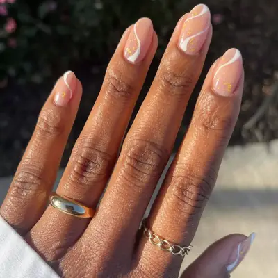 Manicure with swirl nail art and gold glitter