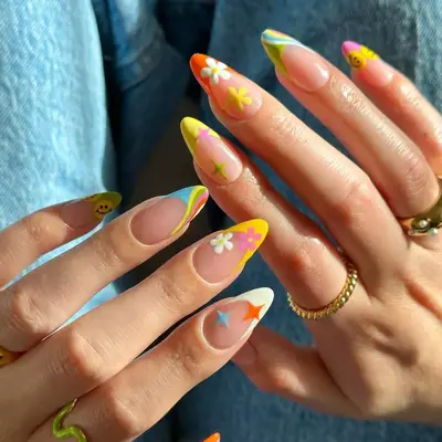 A manicure with mixed nail art including daisies and smily faces