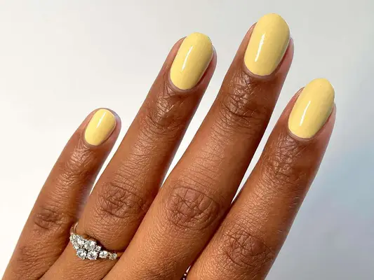 A butter yellow manicure with subtle glitter