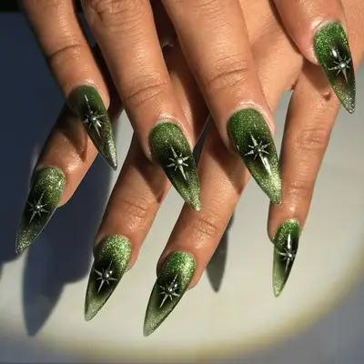Green velvet almond nails with silver stars.