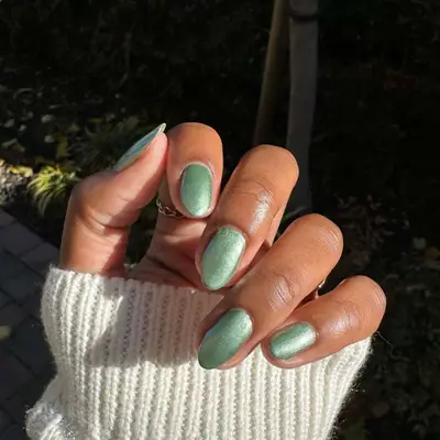 Sage-green manicure with metallic gold pearl flecks.