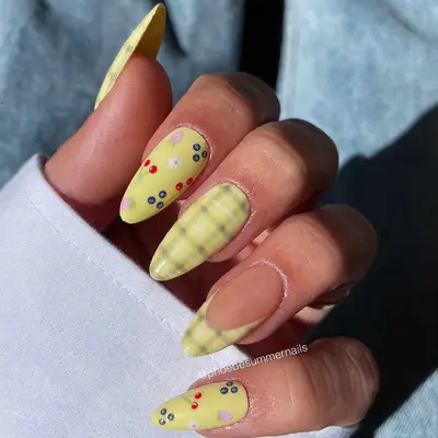 A yellow manicure with plaid and fruit salad details