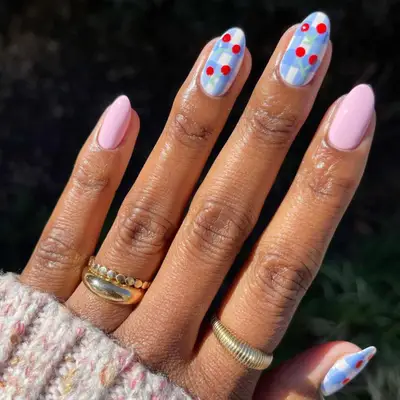 Pink nails interspersed with blue and white checkered nails with cherry decals.