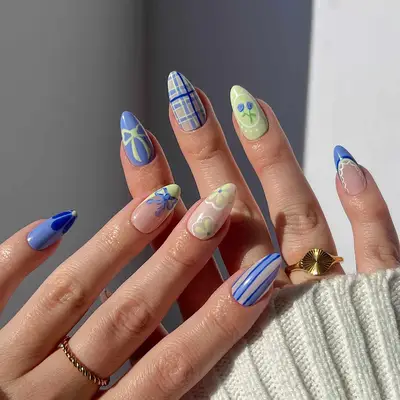 Manicure with plaid, striped, bow, and flower details in yellow and blue