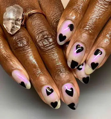 a sheer opalescent manicure with black hearts