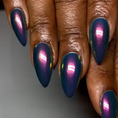 a blue manicure topped in purple chrome