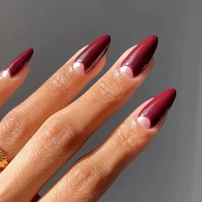 a garnet manicure with subtle glittery half-moons at the cuticle