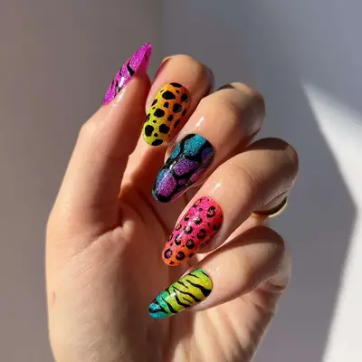 a lisa frank-themed manicure with leopard and cheetah print nails