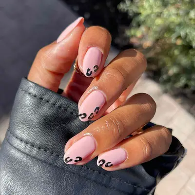 a pink manicure with subtle leopard accents on the corners