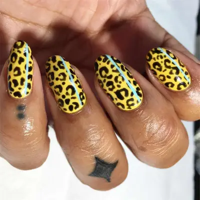 yellow cheetah print nails with baby blue accent stripe