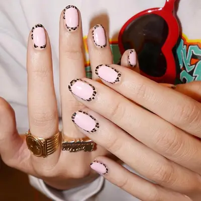baby pink manicure with a cheetah print outline around the entire nail