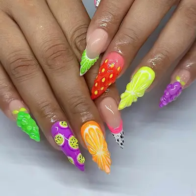 Close-up of hands with elaborately designed nail art featuring various colorful fruit designs