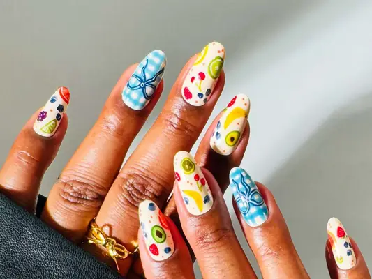 Decorative nail art on hands with colorful patterns on each nail