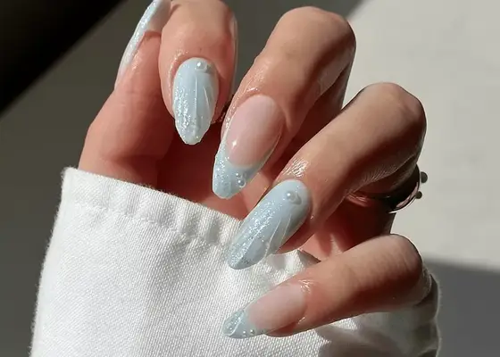 close up of powder blue seashell manicure with pearl accents