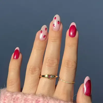 a raspberry and light pink french manicure with strawberry nail art