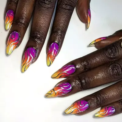 Close up of long hot pink and orange nails with silver accent art.
