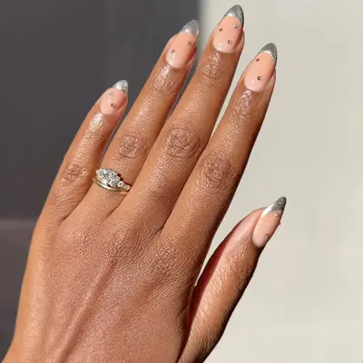 Close up of silver chunky glitter French manicure.