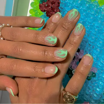 negative space nails with neon green flame and french tip design