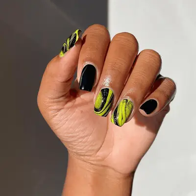 neon yellow and black swirl nails with glitter