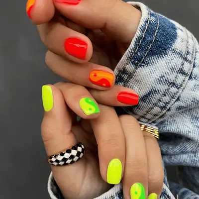 neon orange yellow and green nails with ying yang nail design