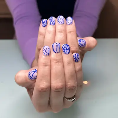 neon electric blue squiggle lines with negative space on short nails