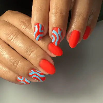 red orange neon nails with pastel blue line designs