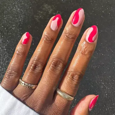 Swirly hot pink design on a pale pink polish base