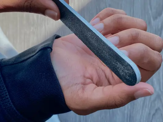 Janiah McKelton filing and prepping nails for press-on nails