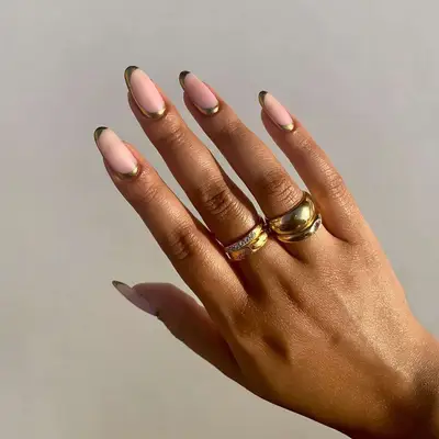 Manicure with neutral base and gold curved outline