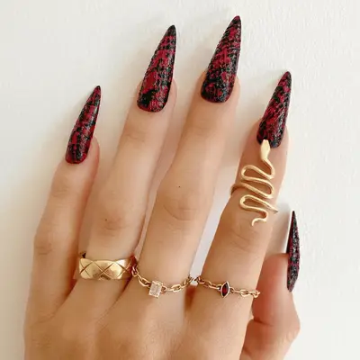 Black and red snake print manicure with texture.